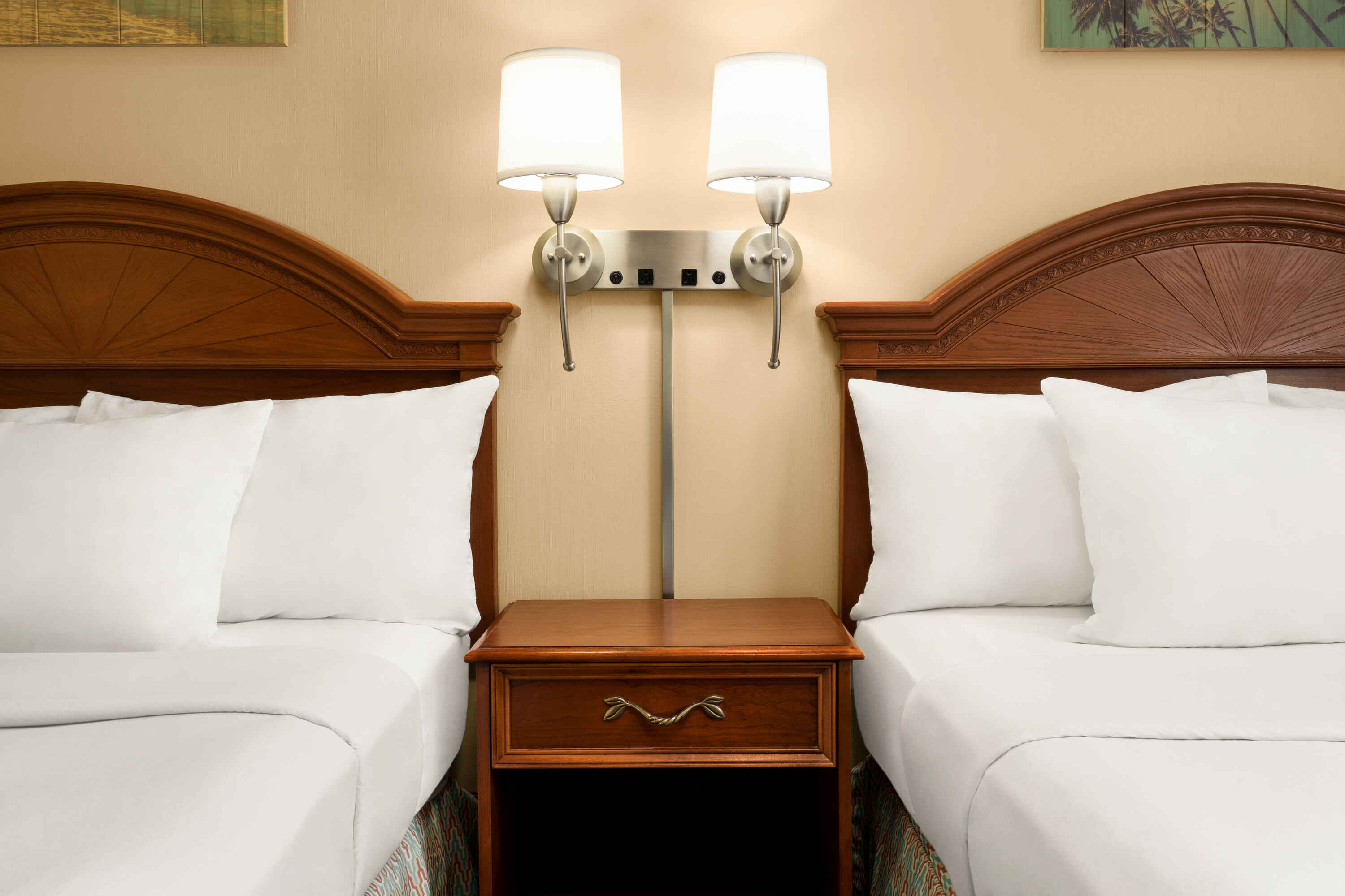 hotel room showing two beds with table and lamp in middle